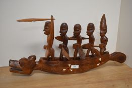 An oriental carved and inlaid boat, depicted with rowing figures aboard.