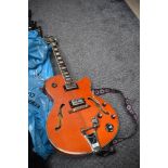 An Epiphone Swingster hollow body electric guitar with Bigsby , in orange finish, serial number