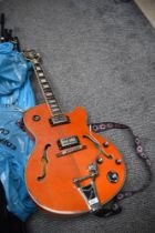 An Epiphone Swingster hollow body electric guitar with Bigsby , in orange finish, serial number