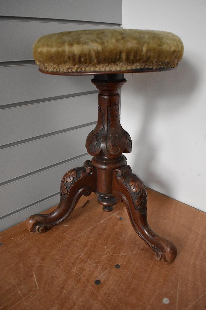 A Victorian mahogany piano stool having revolving adjustable seat