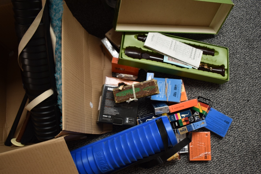 A box of assorted small instruments such as harmonicas etc including saxophone and clarinet reeds