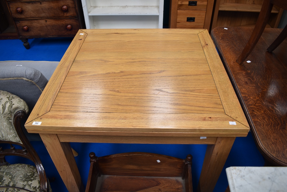 A modern oak extending dining table of square form