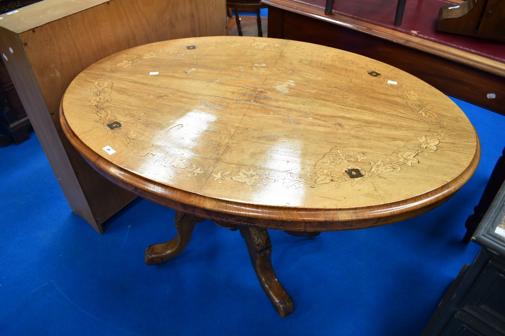 A 19th Century loo table of oval form with quarter veneered top having inlaid foliate decoration