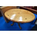 A 19th Century loo table of oval form with quarter veneered top having inlaid foliate decoration