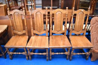 A set of four modern colonial style dining chairs having solid seats and backs