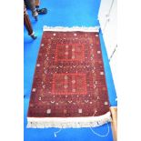 A traditional Persian rug, for prayer or fireside use having red ground with cream, green and orange