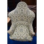 A Queen Anne style wing back armchair having floral upholstery