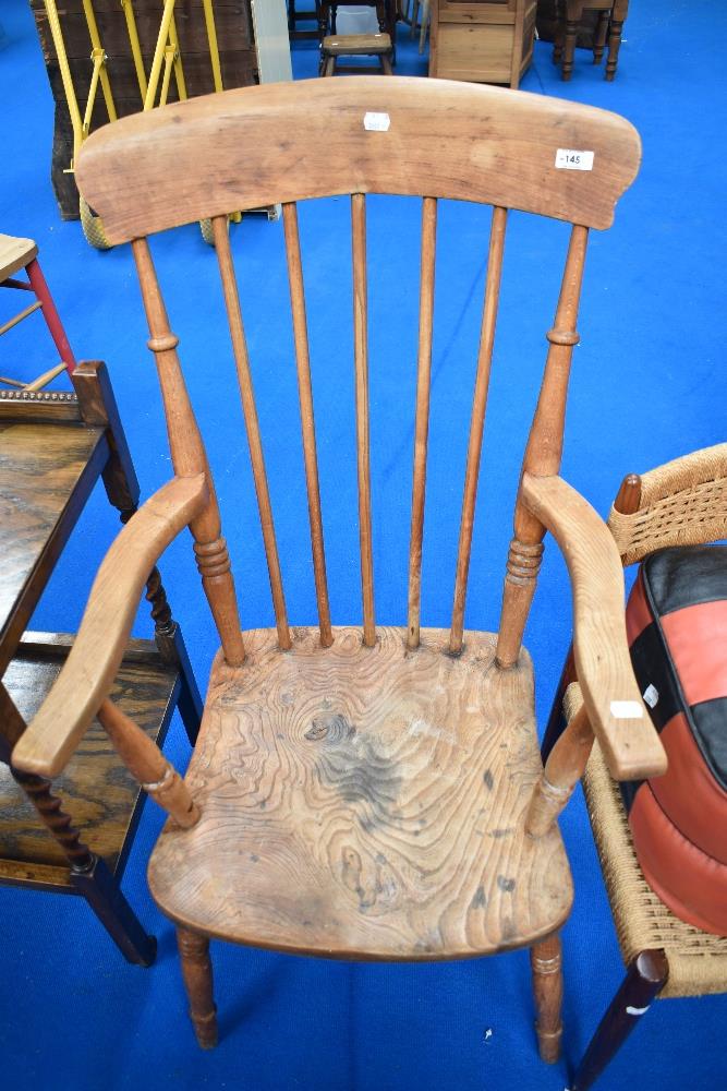 A 19th Century elm armchair of traditional form having spindle back and solid seat