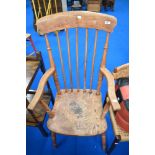 A 19th Century elm armchair of traditional form having spindle back and solid seat