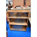 A minty or similar stacking bookcase, in oak having three tiers and castors