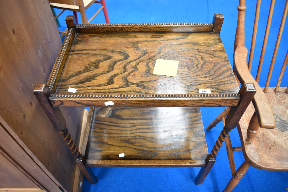 An early 20th Century oak tea trolley having twist frame