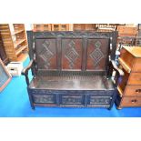 A 19th Century dark oak three panel monks bench/settle having carved decoration