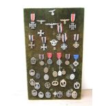 A collection of WWII German Medals and Badges including Iron Cross with ribbons x2, War Merit