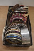 A collection of bangles of various design including a thick engraved buckle style closure bangle,