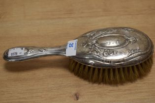 An Edwardian silver mounted hair brush, of traditional design, some denting to body