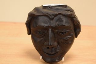 An interesting carved oak mask depicting winking male face, of European appearance