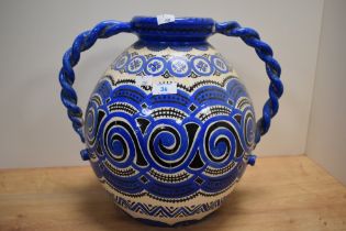 A large continental twin handled vessel, having white ground with blue and black pattern and twisted
