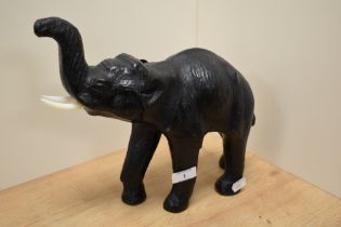 In the manner of Liberty & Co, an embossed leather covered elephant study, with plastic ivory effect