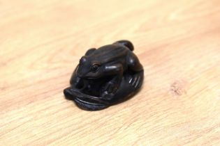 A highly detailed carved Japanese Meiji period style hardwood frog netsuke, with inset glass eyes,