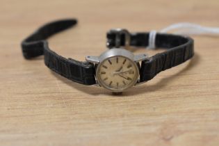 A lady's Omega wristwatch having a baton numeral dial to small silvered face in a steel case on a