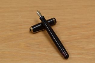 A Parker Vacumatic button fill fountain pen in red pearl with three band cap having Parker 46
