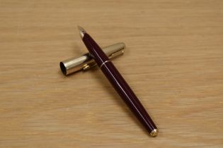 A Parker 65 Custom converter fill fountain pen in burgundy with rolled gold cap having Parker 14K