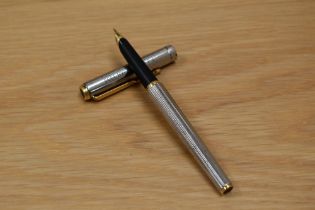 A Parker cartridge fill fountain pen silver coloured with gold trim. Engraved.