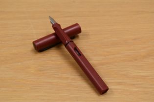 A Lamy Al-Star converter fill fountain pen in magenta with black trim.