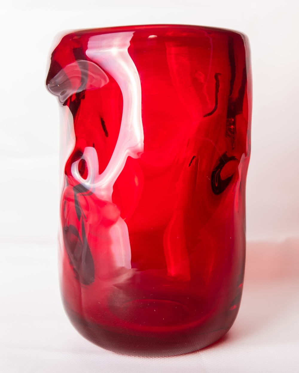 A large 1960s Whitefriars glass 'Knobbly' vase in ruby red, designed by William Wilson and Harry