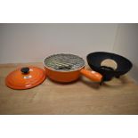 A vintage Le Creuset orange cast fondue set.