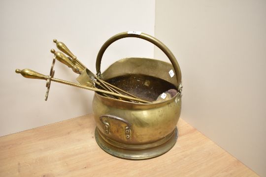 A brass coal helmet, of traditional design and sold along with a selection of horse brasses and