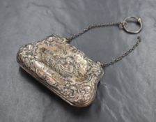 An Edwardian silver purse, having embossed scroll work and a scene depicting two women, one carrying