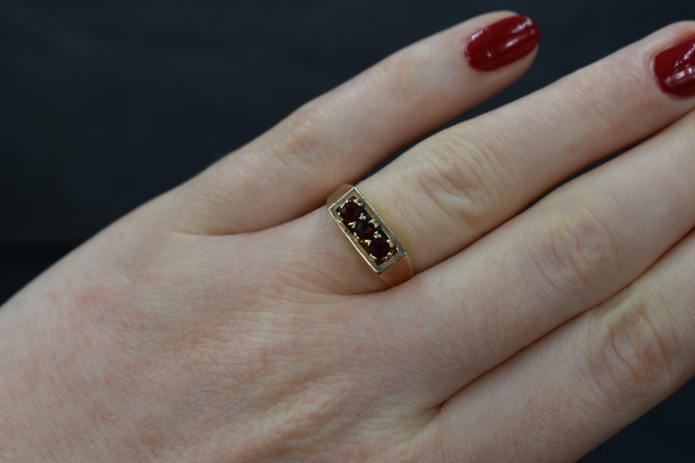 A 9ct gold garnet trilogy ring having a claw set mount in a box style setting, size N & approx 2.4g - Image 3 of 3