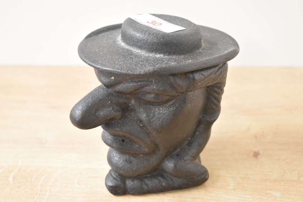 A cast iron Mr Punch tobacco jar depicting a bust of a grotesque figure, his hat forming the