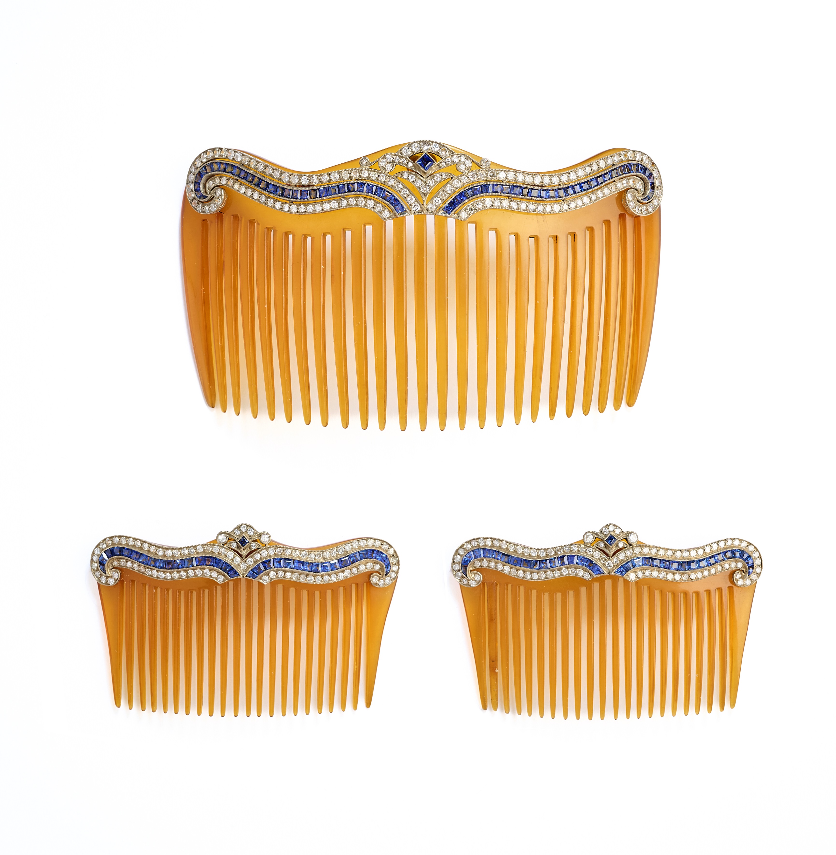 ˜ A SET OF THREE BELLE EPOQUE BLOND TORTOISESHELL, SAPPHIRE AND DIAMOND HAIR COMBS, CIRCA 1910