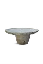 A LARGE ANTIQUE GRANITE CIRCULAR MILLSTONE mounted on a granite base as a table. 176cm diameter,