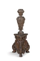 A CARVED WALNUT TORCHERE, ITALIAN 17TH CENTURY, the baluster column carved with masks and swags