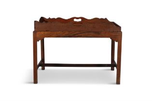 A MAHOGANY BUTLER'S TRAY ON STAND, the tray with inset carrying handles, raised on square legs