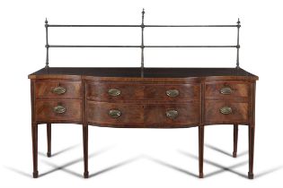 A GEORGE III INLAID MAHOGANY SERPENTINE SIDEBOARD surmounted by brass gallery rail over a