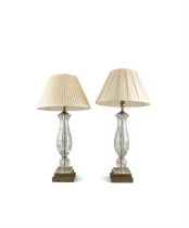 A PAIR OF CLEAR GLASS AND BRASS MOUNTED TABLE LAMPS, the circular baluster columns raised on