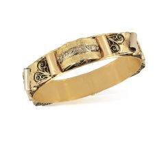 A GOLD BANGLE, the bangle set with half barrel-shape motifs with engraved foliate decoration and