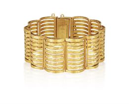 A GOLD BRACELET, of undulating openwork design, each panel with an engraved and polished finish,