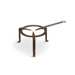 A CIRCULAR WROUGHT IRON TRIVET with tripod supports. 17.5cm high, 53cm wide, 25cm diameter