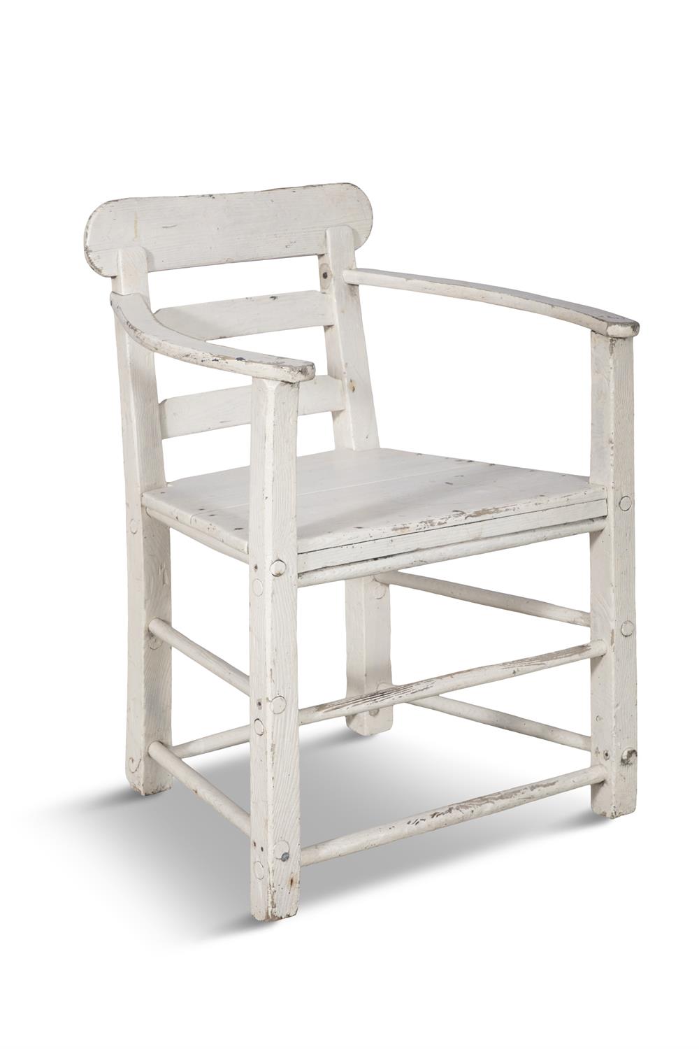 A WHITE PAINTED PINE ARCMCHAIR with ladder back and slightly bowed armrests, panelled seat and