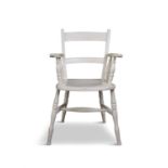 A WHITE PAINTED PINE CURVED RAILBACK CHAIR with scroll armrests, dished saddle seat on splayed