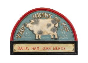 A PAINTED TIMBER SHOP SIGN, arch top with relief pig and inscribed 'Thomas Brown & Son,