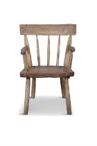 A STAINED TIMBER HEDGE CHAIR with carved rail backs, and spindle supports, plain armrest and
