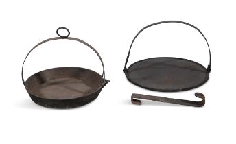 TWO IRON CIRCULAR SKILLET BASES, one with fixed handle and the other with swing handle,