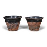 A PAIR OF TERRACOTTA MILK CROCKS, the moulded rim above black glazed body with thrown handles.