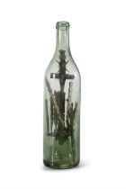 AN UNUSUAL IRISH FOLK ART 'GOD IN A BOTTLE' the green tinged glass bottle with crucifix mounted